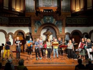 Foto: 17k&ouml;pfiges Orchester spielt im Altarraum einer Kirche