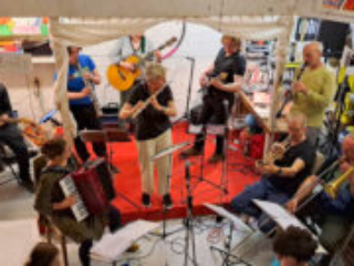 Foto: Orchester mit akustischen Instrumenten spielt in einem kleinen Atelierraum - Blick von oben