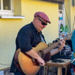 Foto: Mann mit Sonnenbrille spielt akustische Gitarre