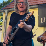 Foto: Mann spielt E-Bass und singt dabei